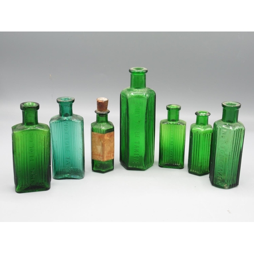 232 - Seven small green glass poison bottles incl. one with original Cooks of Lincoln shop sticker (7)