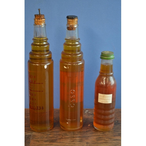 290 - Three vintage moulded glass oil bottles with contents to include 1 quart examples from Esso and a sm... 