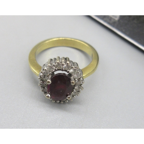 12 - 18ct yellow gold cluster ring set with oval cut ruby surrounded by a halo of white sapphires, stampe... 