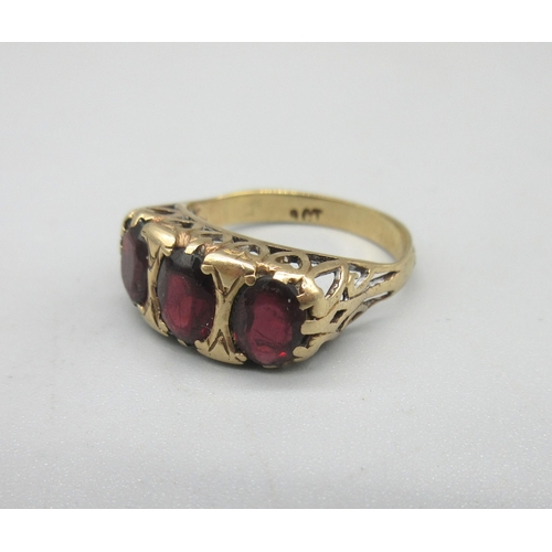 14 - 9ct yellow gold ring set with three red stones in ornate mount, stamped 9ct, size N1/2, 3.5g