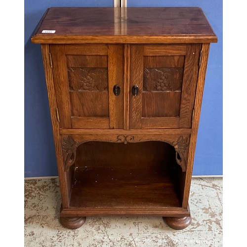 1143 - Edwardian oak side cabinet, two carved panel doors above a recess, on bun feet, W55cm D29cm H84cm