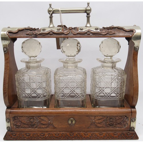 416 - 20th century oak tantalus, three cut glass decanters, carved floral decoration, EPNS mounts, H35cm