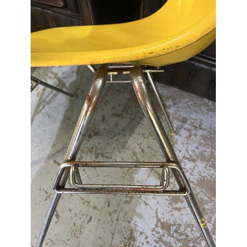 621 - Four vintage Eames for Herman Miller yellow fibreglass and chrome plated DSS stacking chairs, moulde... 