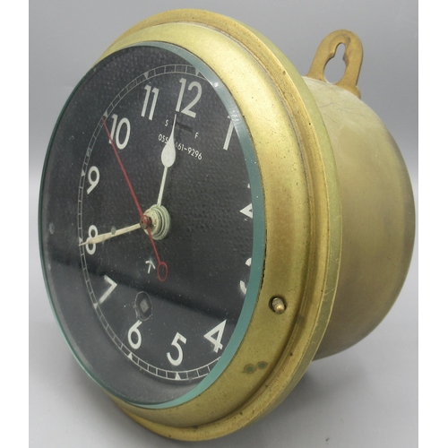 1121 - British Royal Navy brass bulkhead clock, black dial with white Arabic numerals, white hands and red ... 