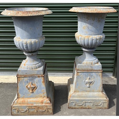 1356 - Pair of Victorian style cast iron garden urns, part lobed bodies on square bases and tapering pedest... 