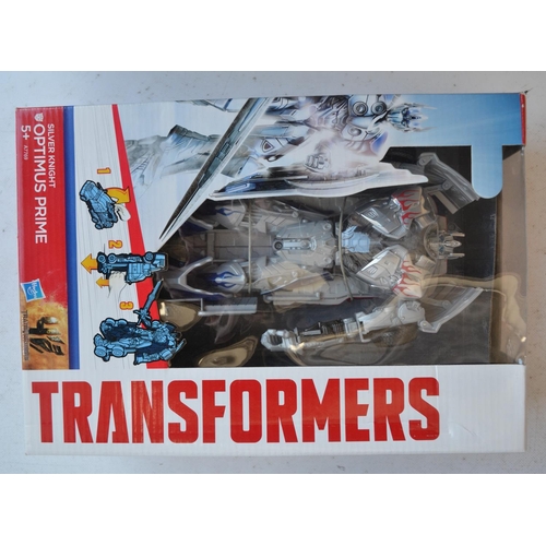 166 - Four Transformer models from Hasbro to include Silver Knight Optimus Prime (approx 8.5