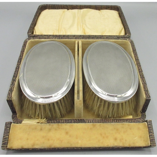 66 - Pair of silver George V brushes with engine turned pattern, in a fitted case by A & J Zimmerman, Bir... 