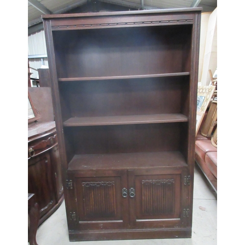 620 - Old Charm oak bookcase with two linenfold panel doors, W93cm D33cm H155cm and an oak bedside cabinet... 