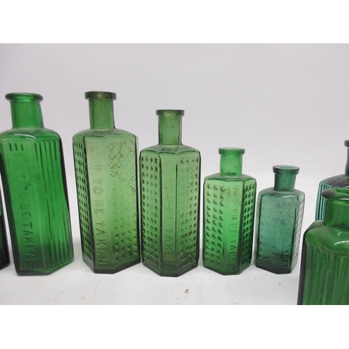 250 - Collection of green glass poison bottles of varying sizes, some with glass ribbing and others with c... 