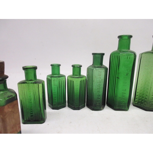 250 - Collection of green glass poison bottles of varying sizes, some with glass ribbing and others with c... 