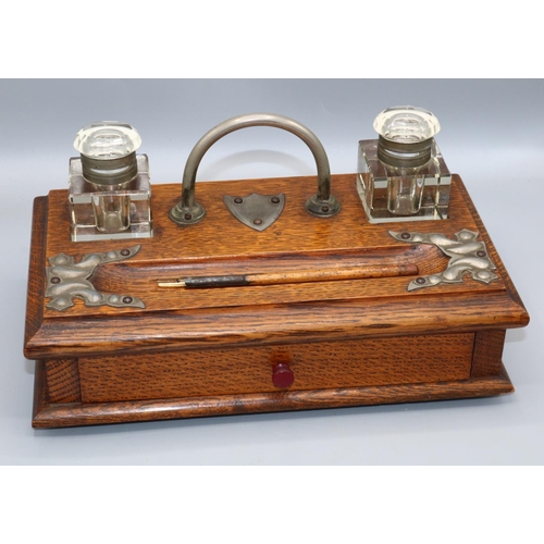 155 - Victorian oak metal mounted desk stand, with two cut glass inkwells and pen recess, over a frieze dr... 