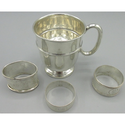 86 - 20th century silver christening mug by Viner's Ltd, Sheffield, 1960, and three silver napkin rings w... 