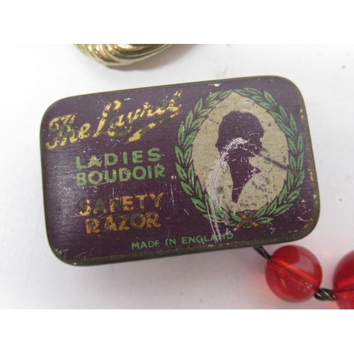 52 - Costume jewellery, a carved ebony letter opener, the Laurel ladies safety razor in tin, a string of ... 