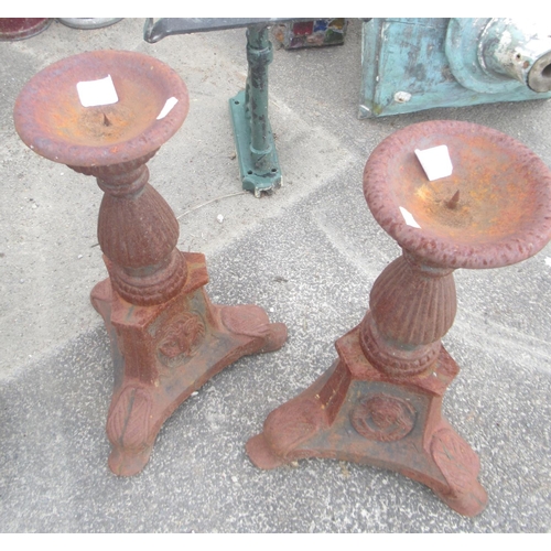 1323 - Small pair of cast iron urns on plinths. Height 50cm. Pair of cast iron ornate tee-light / candle st... 