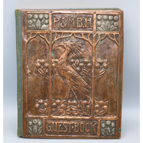 194 - Arts and Crafts copper mounted guest book, the embossed cover decorated with a bird and berries view...