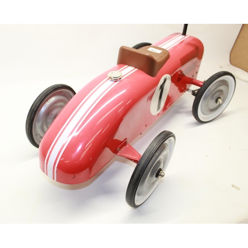 882 - Children's painted ride on tin plate car in the form pre-war Grand Prix racing car, L73cm