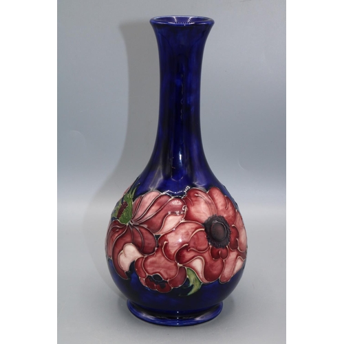 363 - Moorcroft Pottery: Anemone pattern bottle form vase, red flowers on dark blue ground, H22cm