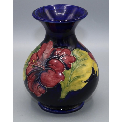 366 - Moorcroft Pottery: Hibiscus pattern vase, red and purple flowers on dark blue ground, H13.5cm