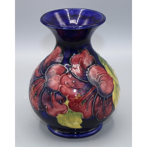 366 - Moorcroft Pottery: Hibiscus pattern vase, red and purple flowers on dark blue ground, H13.5cm