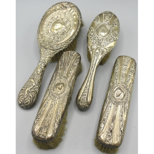 79 - Victorian silver set of four brushes with scrolling repousse decoration, makers mark LS, Birmingham,... 