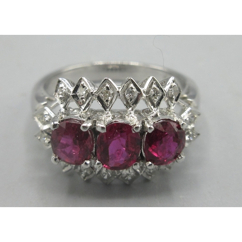 165 - White metal ring set with three rubies surrounded by diamonds, unmarked, size M, 4.27g