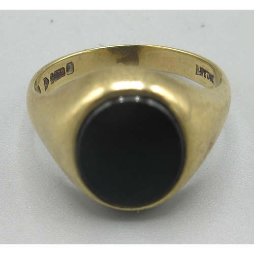 169 - 9ct yellow gold signet ring, the oval face set with polished black stone, stamped 375, size S, 6.16g