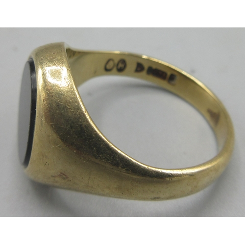 169 - 9ct yellow gold signet ring, the oval face set with polished black stone, stamped 375, size S, 6.16g