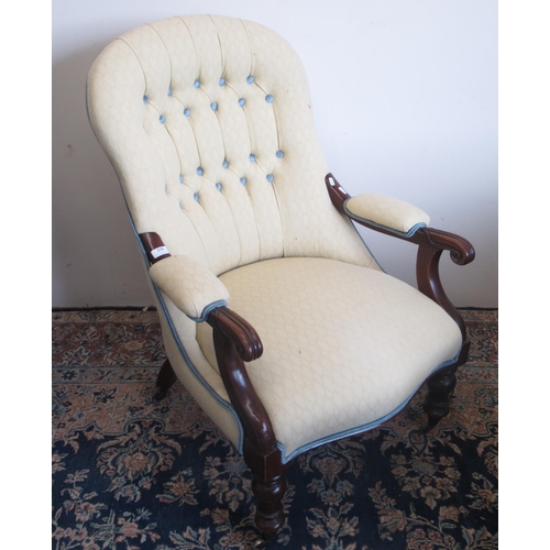 256 - Victorian mahogany upholstered open arm chair, with buttoned back and scroll carved arms on turned s... 