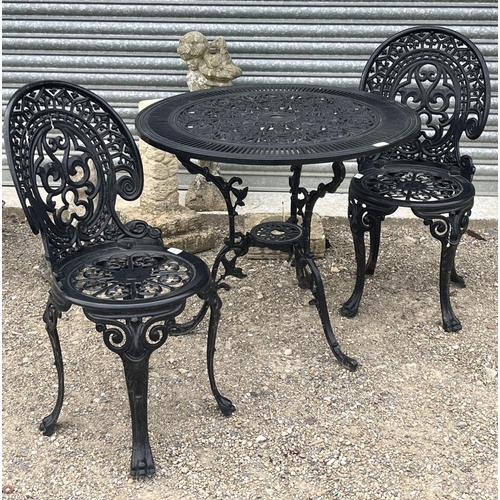 718 - Reproduction Victorian style black painted aluminium circular garden table and two chairs (3)