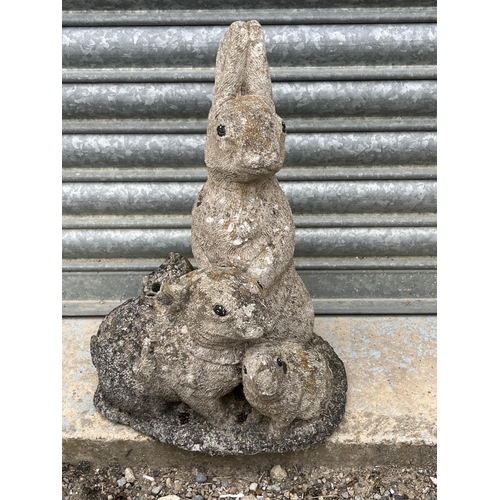 722 - Reconstituted stone garden figure of three rabbits