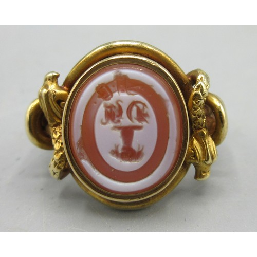 581 - Late Georgian unmarked yellow metal intaglio ring, set with carnelian with unknown engraved coat of ... 