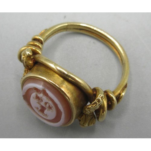 581 - Late Georgian unmarked yellow metal intaglio ring, set with carnelian with unknown engraved coat of ... 