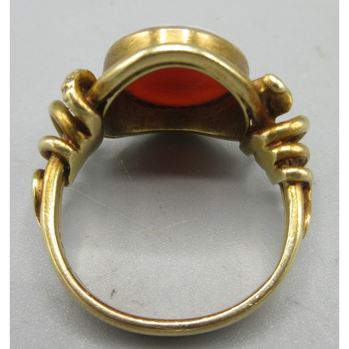 581 - Late Georgian unmarked yellow metal intaglio ring, set with carnelian with unknown engraved coat of ... 