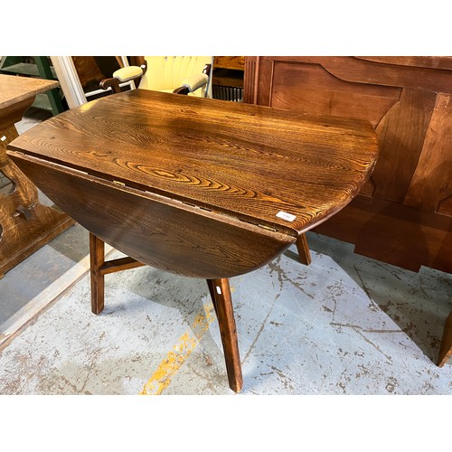 736 - Ercol elm circular drop leaf table, X shaped under strecher, D113cm