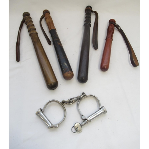 268 - Collection of four vintage wooden police truncheons and a set of handcuffs, complete with original k... 