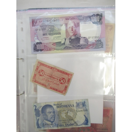 226 - Two folders containing assorted collection of International banknotes from Venezula, Angola, Ghana, ... 