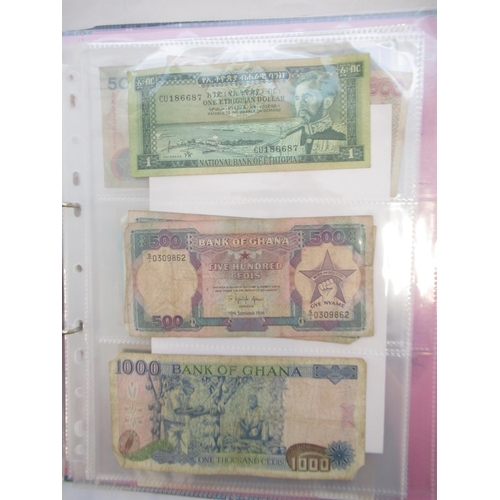 226 - Two folders containing assorted collection of International banknotes from Venezula, Angola, Ghana, ... 