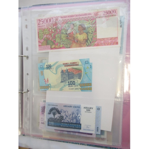 226 - Two folders containing assorted collection of International banknotes from Venezula, Angola, Ghana, ... 