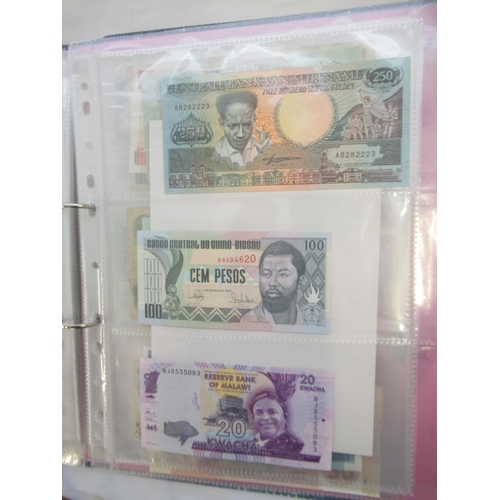 226 - Two folders containing assorted collection of International banknotes from Venezula, Angola, Ghana, ... 