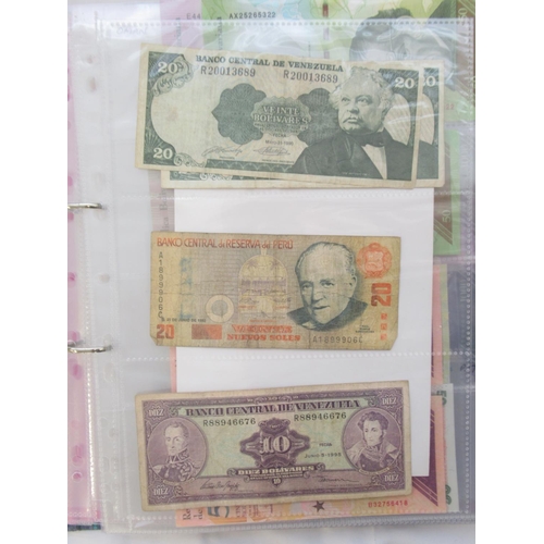 226 - Two folders containing assorted collection of International banknotes from Venezula, Angola, Ghana, ... 