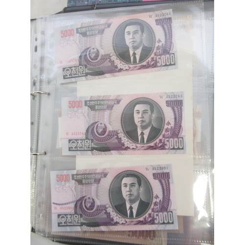 228 - Two folders containing mixed International banknotes from North Korea, Singapore, Indonesia, Malaysi... 