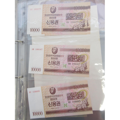 228 - Two folders containing mixed International banknotes from North Korea, Singapore, Indonesia, Malaysi... 