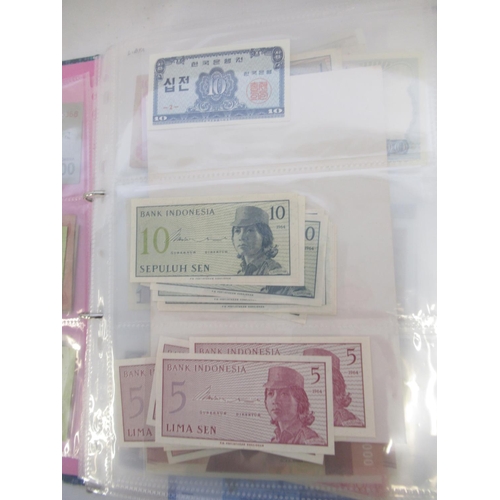 228 - Two folders containing mixed International banknotes from North Korea, Singapore, Indonesia, Malaysi... 