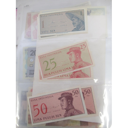 228 - Two folders containing mixed International banknotes from North Korea, Singapore, Indonesia, Malaysi... 