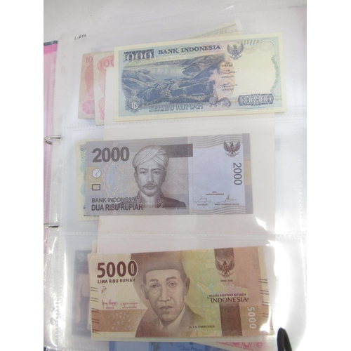 228 - Two folders containing mixed International banknotes from North Korea, Singapore, Indonesia, Malaysi... 