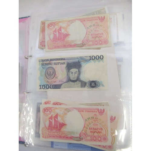 228 - Two folders containing mixed International banknotes from North Korea, Singapore, Indonesia, Malaysi... 