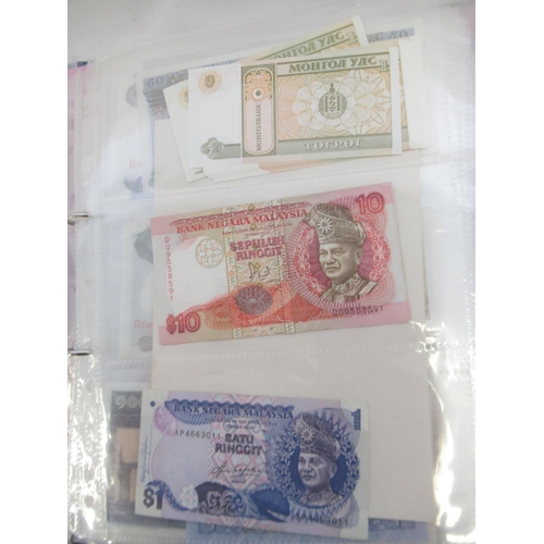 228 - Two folders containing mixed International banknotes from North Korea, Singapore, Indonesia, Malaysi... 