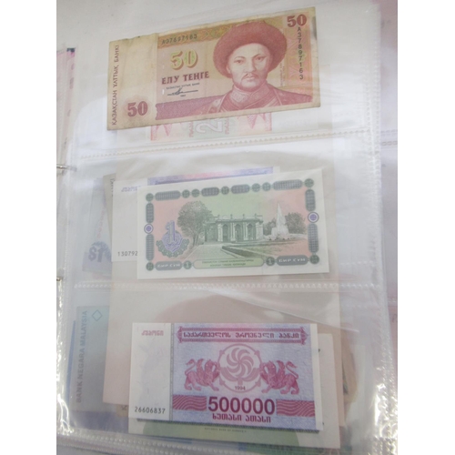 228 - Two folders containing mixed International banknotes from North Korea, Singapore, Indonesia, Malaysi... 