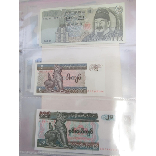 228 - Two folders containing mixed International banknotes from North Korea, Singapore, Indonesia, Malaysi... 