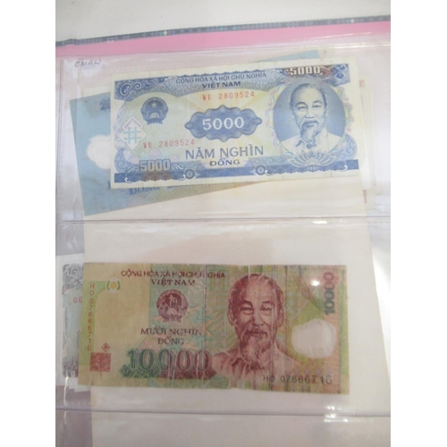 228 - Two folders containing mixed International banknotes from North Korea, Singapore, Indonesia, Malaysi... 